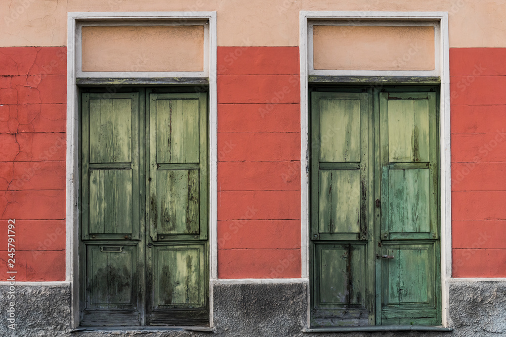 due antiche porte verdi su muro rosso due antiche porte verdi su muro rosso