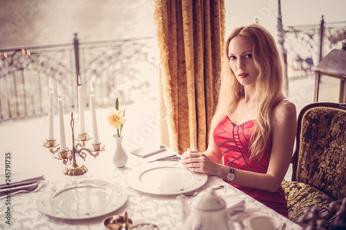beautiful fashion woman in red dress in restaurant photo