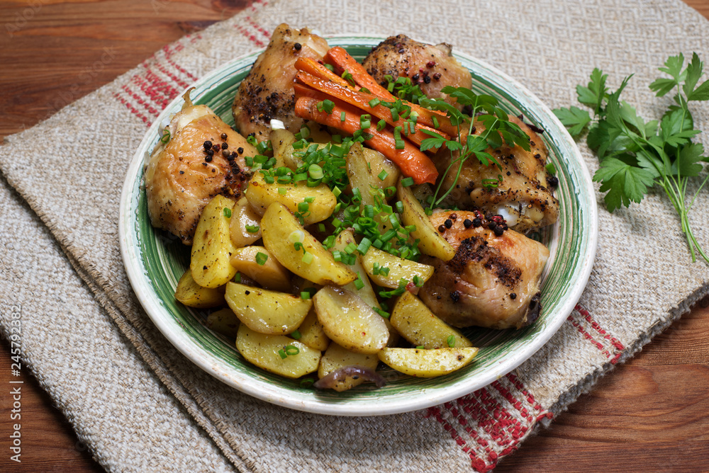 Baked chicken legs with potatoes and carrots under spices and seasonings Baked chicken legs with potatoes and carrots under spices and seasonings