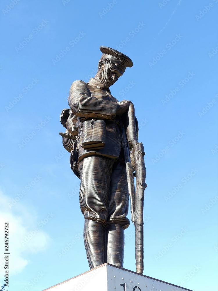 Statue of a lone soldier on a plinth in The Memorial Gardens in Old Amersham, Buckinghamshire, UK