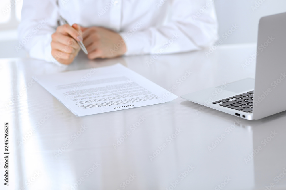 Close-up of female hands with pen over document, business concept. Lawyer or business woman at work in office Close-up of female hands with pen over document, business concept. Lawyer or business woman at work in office