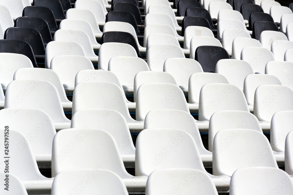 Fototapeta premium Empty black and white stadium seats mixed in rows, diversity concept