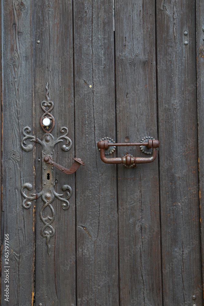 old wooden door with a wrought iron lock old wooden door with a wrought iron lock