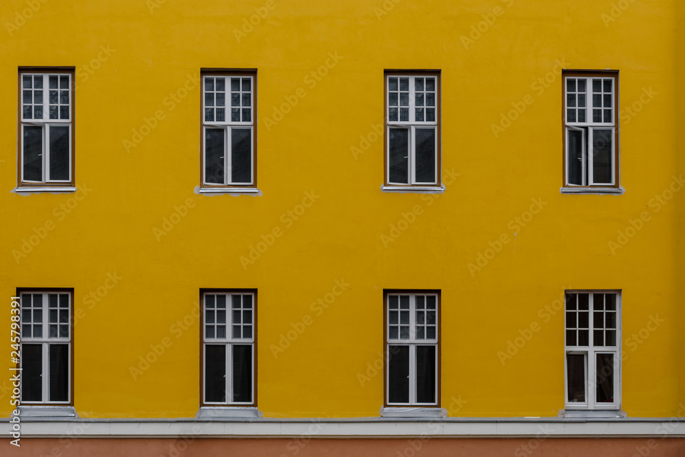 Closeup photo of bright yellow building with eight windows