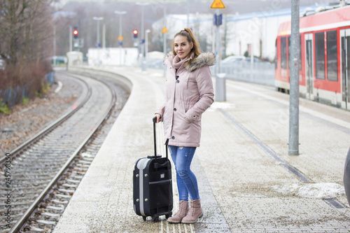 Junge Frau mit Koffer am Bahnhof  © Waler