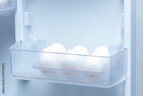 chicken eggs on a plastic tray in the fridge