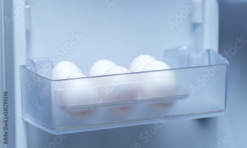 chicken eggs on a plastic tray in the fridge
