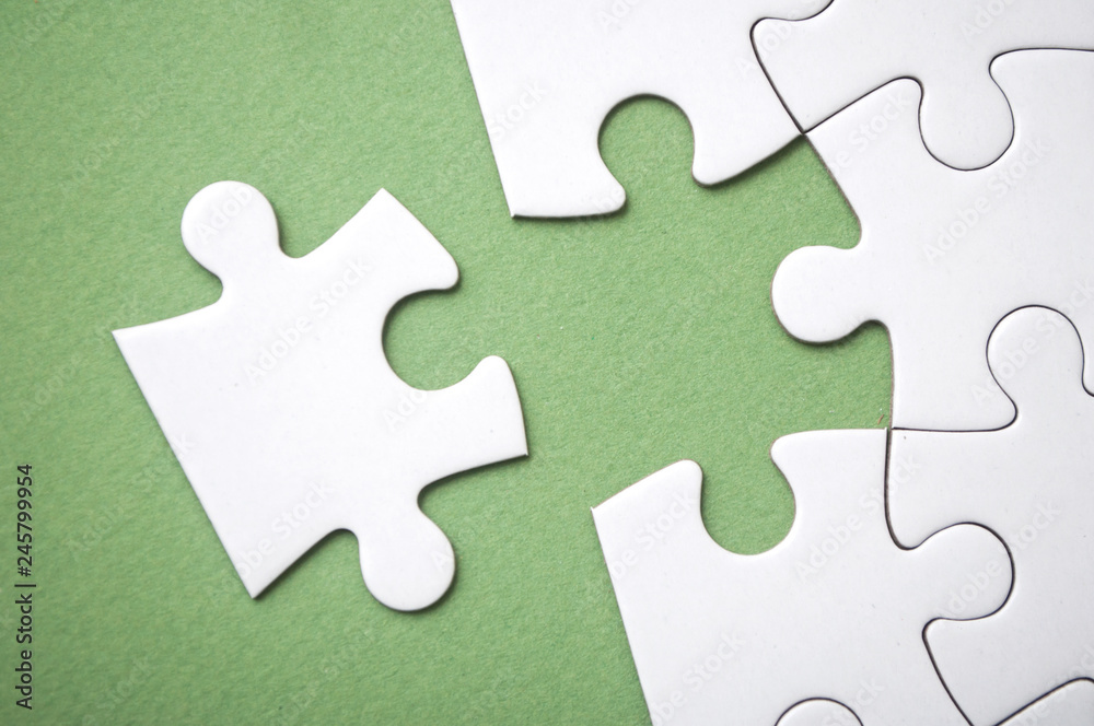 closeup of the last piece of jigsaw puzzle missing on green background to complete the mission closeup of the last piece of jigsaw puzzle missing on green background to complete the mission