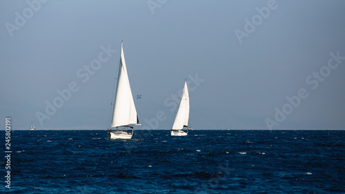 Yacht with white sails in the Aegean sea. Sailing.