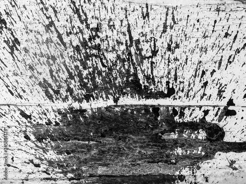 une tache d'encre noire projetée sur un mur blanc