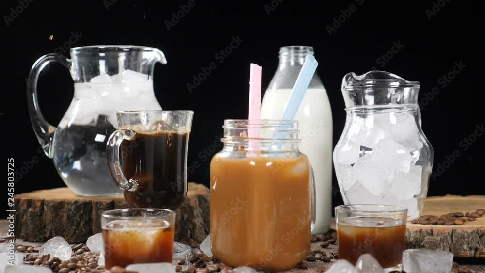 Cube of ice falling down in hot coffee with bright splashes in slow motion. Brown theme. Foodart shot from commercial. hd Cube of ice falling down in hot coffee with bright splashes in slow motion. Brown theme. Foodart shot from commercial. hd