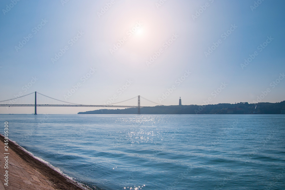 Fototapeta premium Lisbon Bridge of 25th april in Portugal. River Tejo in sunny day in Lisboa.