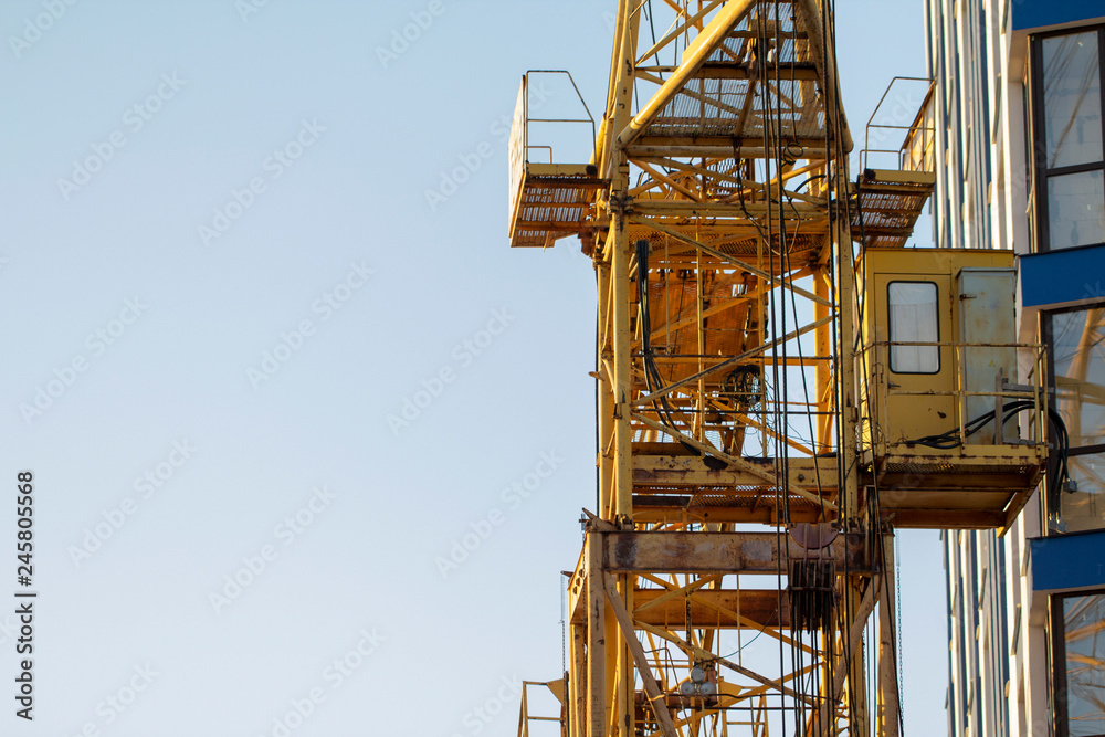 Construction cranes and high-rise building under construction against blue sky. Construction cranes and high-rise building under construction against blue sky.