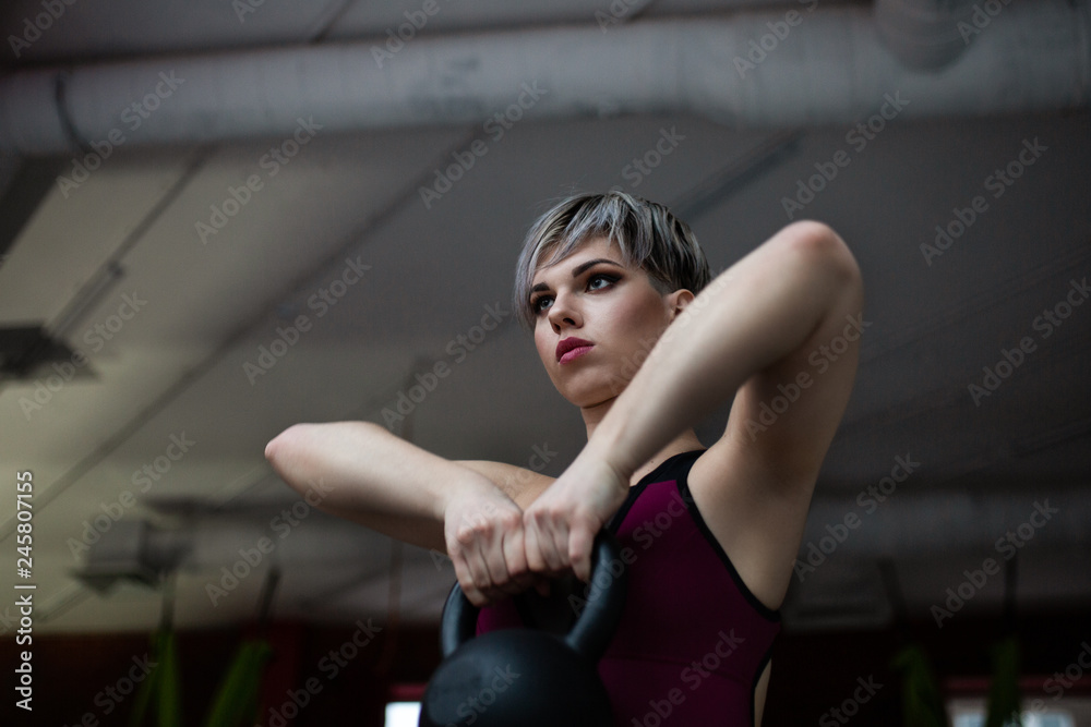 Woman doing kettle bell exercise in a gym Woman doing kettle bell exercise in a gym