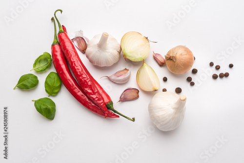 A set of additions to prepare dishes. Popular ingredients for an Italian meal. Chillies, red chillies, basil or onion with spices isolated on white background. photo