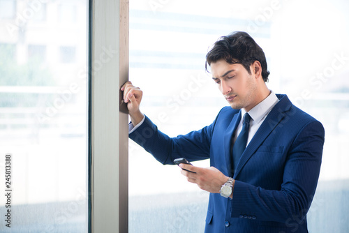 Young handsome businessman standing at the window 