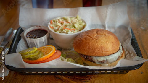 Cheeseburger and coleslaw on a tray in a restaurant setting