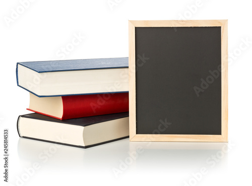 Empty, blank, black chalkboard with stack of books over white