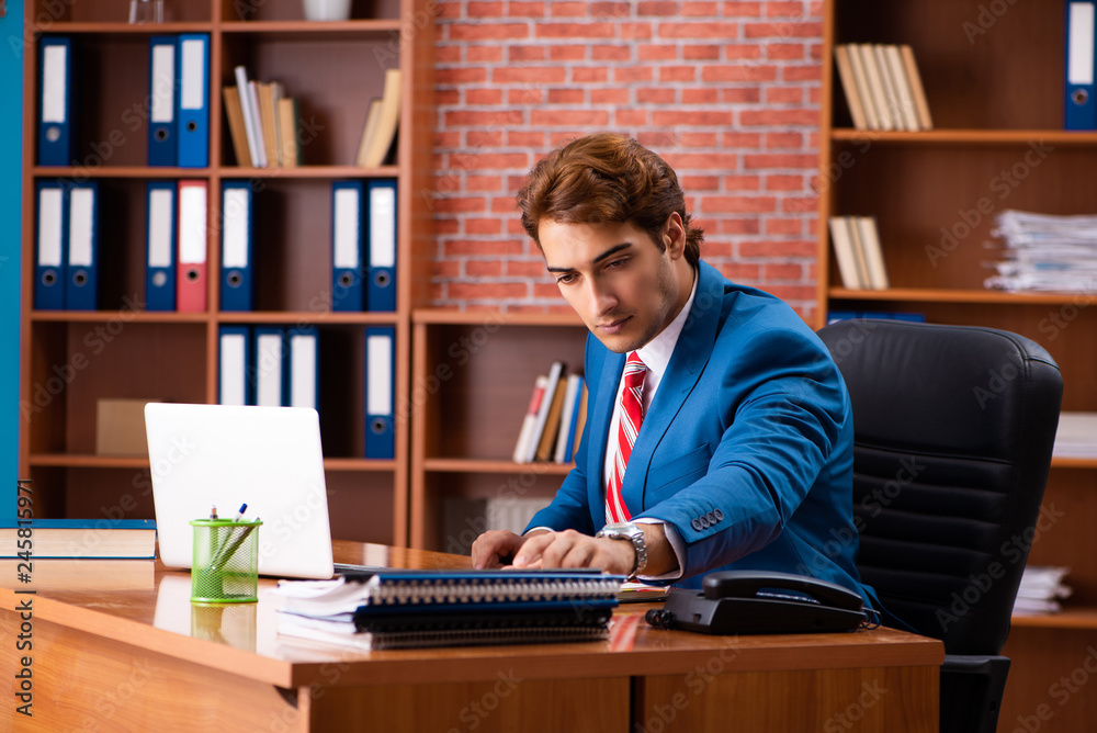 Young handsome employee sitting in the office Young handsome employee sitting in the office