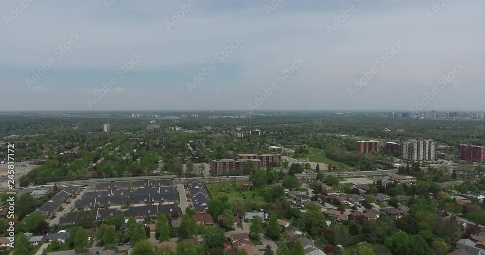 Panorama Aerial Cloudy Sky Over Rows Of Houses And Green Trees With White Apartment Building And Shopping Center Panorama Aerial Cloudy Sky Over Rows Of Houses And Green Trees With White Apartment Building And Shopping Center