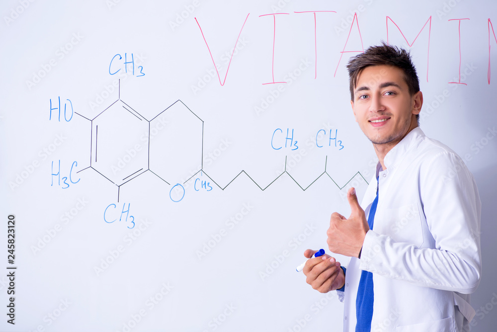 Young chemist standing in front of the whiteboard Young chemist standing in front of the whiteboard