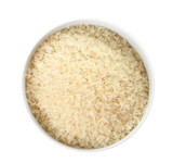 Bowl with uncooked parboiled rice on white background, top view