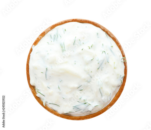 Bowl with cucumber sauce on white background, top view