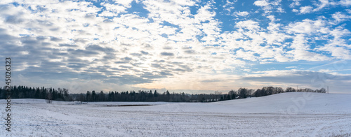 Fototapeta Naklejka Na Ścianę i Meble -  Panoramic Countryside Landscape in Sunny Winter Day with Snow Covering the Ground, Abstract Background with Deep Look and Dramatic Skies - Concept of Harmony, Peace and Traveling