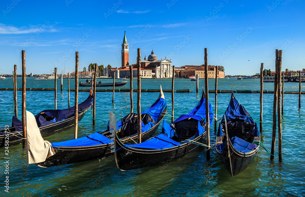 Gondolas on the background of San Giorgio Maggiore island and Cathedral of the same name. View from the waterfront near Saint Mark's square. Venice, Italy.