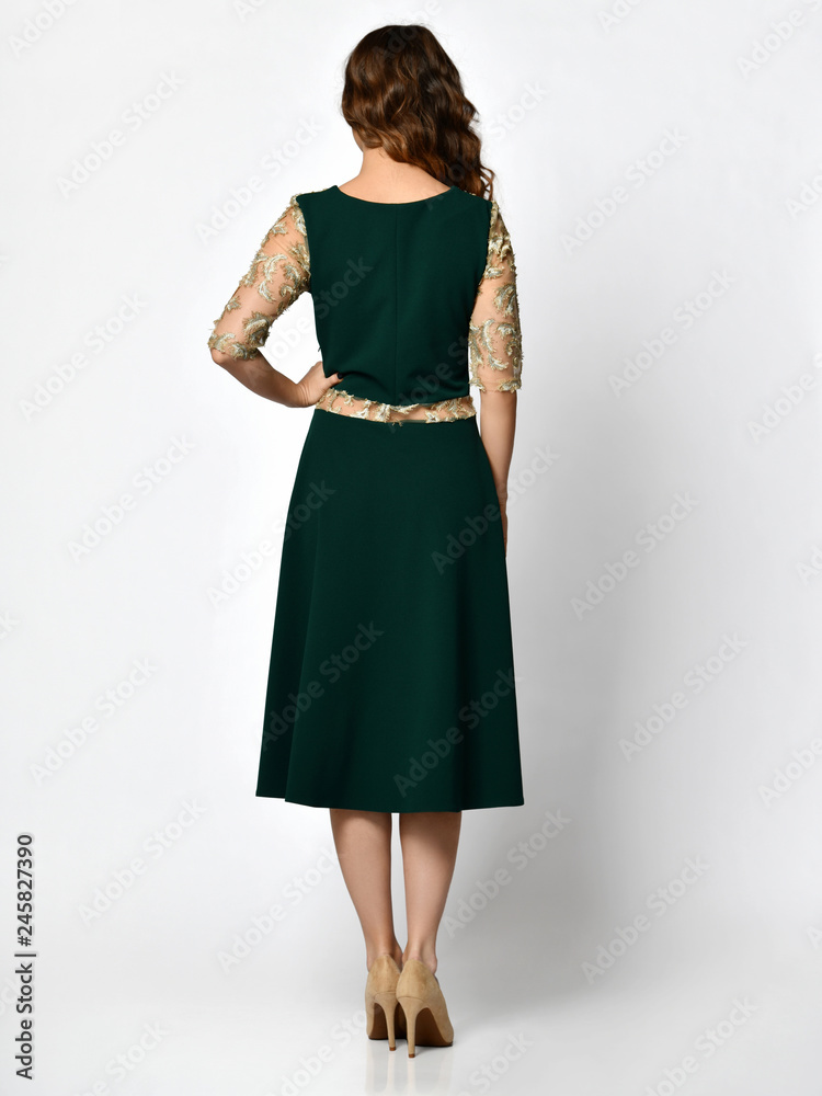 Fototapeta premium Young beautiful woman posing in new dark black fashion winter dress backside rear view