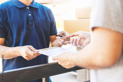Customer Man signature in clipboard to receive package from professional delivery man at home