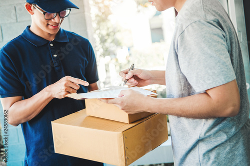 Customer Man signature in clipboard to receive package from professional delivery man at home photo