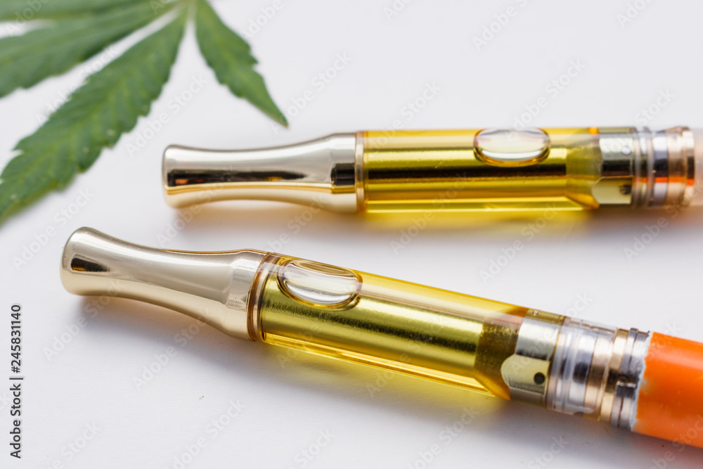 Full Gram THC/CBD Concentrated Oil In Cartridges Closeup Marijuana Leaf On White Full Gram THC/CBD Concentrated Oil In Cartridges Closeup Marijuana Leaf On White