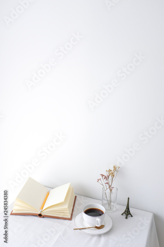Glass vase of dried flower plant a white vintage ceramic cup of coffee an eif...