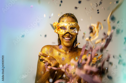 Beautiful woman and confetti falling in your hands. Celebration, event or carnival concept. Movement and happiness having fun. Brazilian Carnaval. © Brastock Images