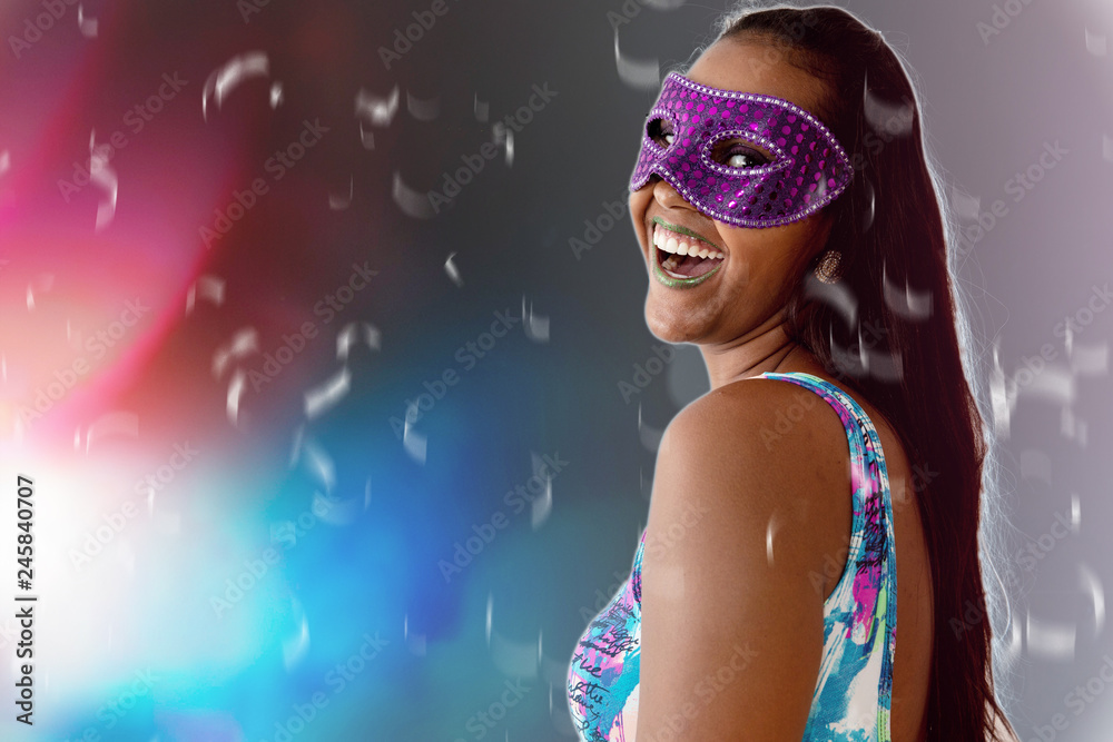 people, holidays, emotion and carnival concept - happy young woman with mask and confetti at carnaval party. Carnaval concept