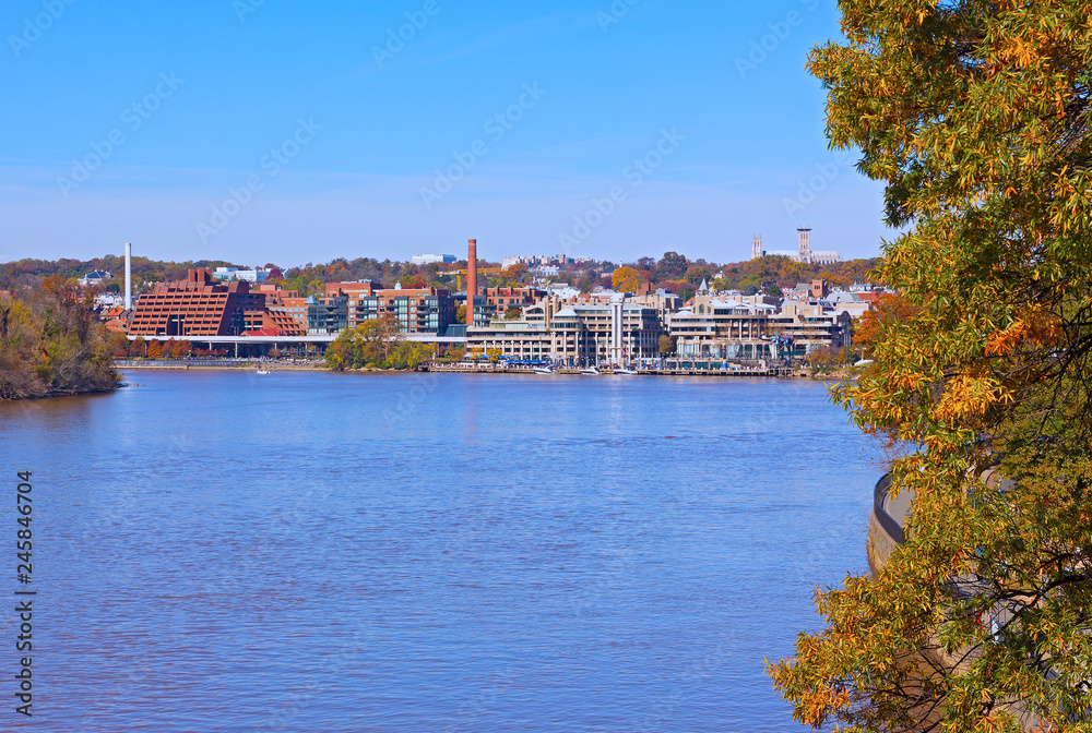 Georgetown waterfront along Potomac River in autumn, Washington DC, USA. Panoramic view on US capital and cityscape with National Cathedral on horizon.