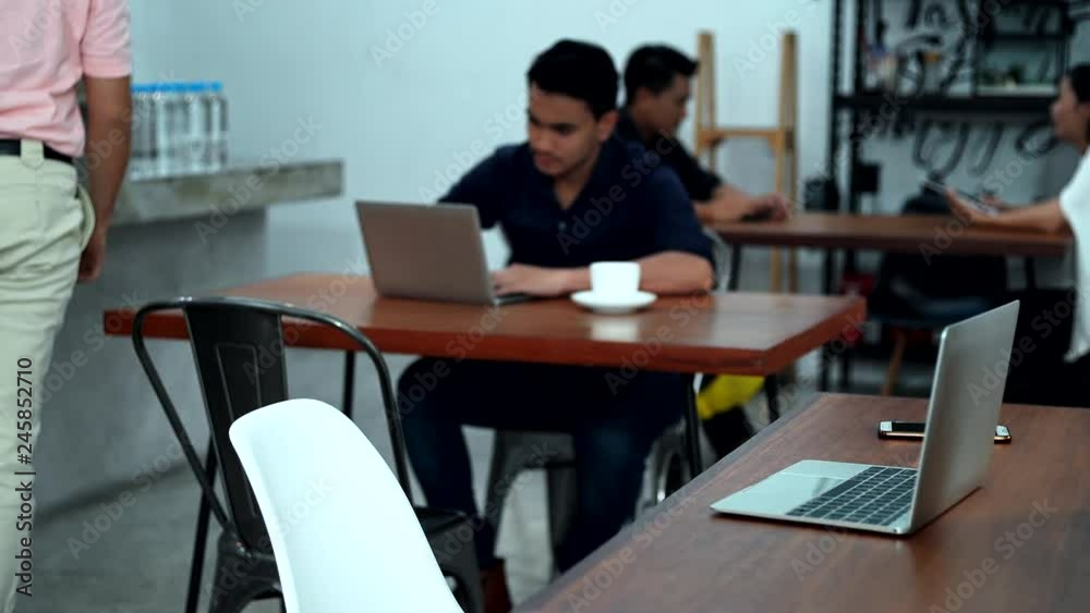 Young man used laptop in cafe and drinking hot coffee Young man used laptop in cafe and drinking hot coffee