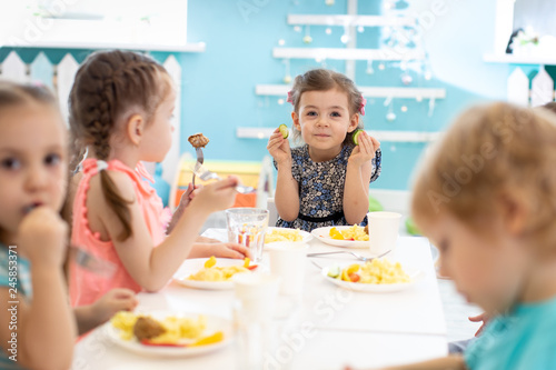 Group of children eating healthy foo in kindergarten