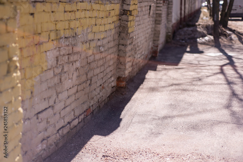long brick high gray fence along the sidewalk