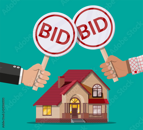Hands holding auction paddle. Real estate house