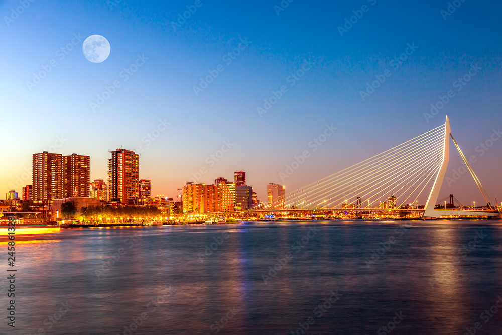 Erasmus bridge over the river Meuse with skyscrapers and moon in Rotterdam, South Holland, Netherlands during twilight sunset. Rotterdam panorama