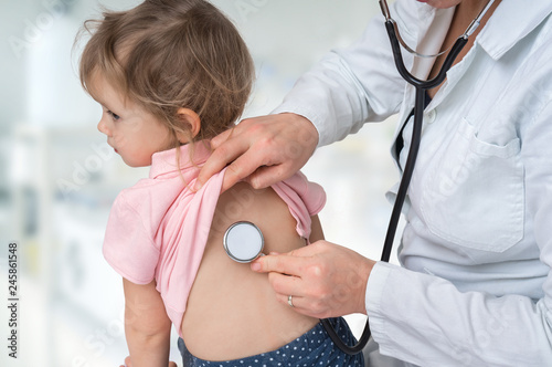 Pediatrician doctor examining a little girl by stethoscope