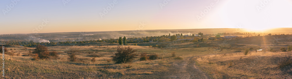 Smoke over the village in the autumn. Burning foliage in Ukraine.