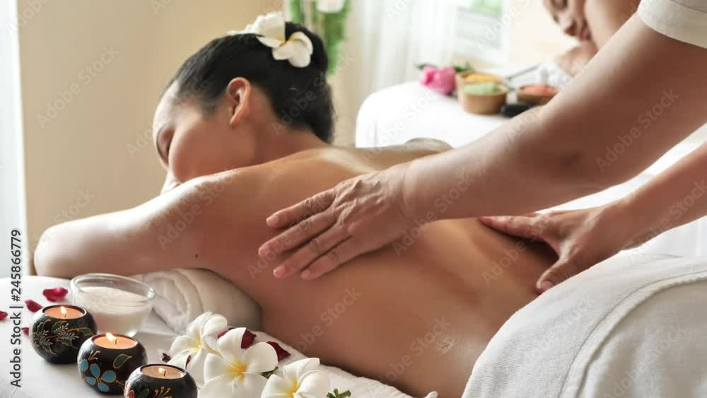Beautiful young asian woman lying on the bed having a massage back with Oil in spa centre. Body care, skin care, health concept