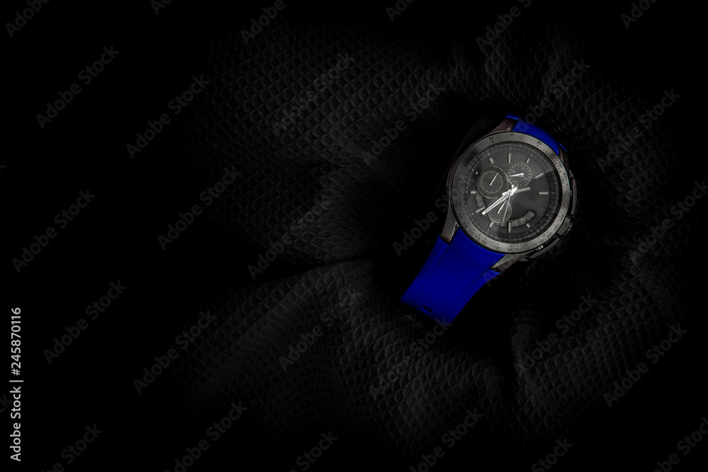 blue coloured watch in a black background