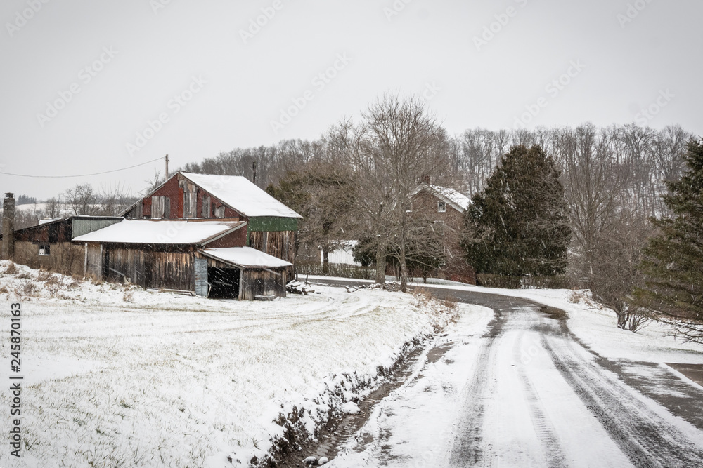 Snow covered lane leading to a weathered barn Snow covered lane leading to a weathered barn