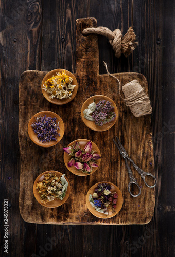 Medicinal healing herbs and flowers for herbal tea on a wooden background, top view. Herbal Medicine