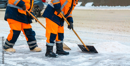 Communal services workers sweep snow from road in winter, Cleaning city streets and roads after snow storm. Moscow, Russia.