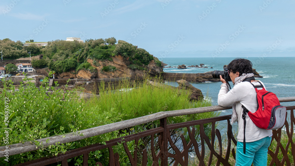 woman photographer taking a picture at seaside